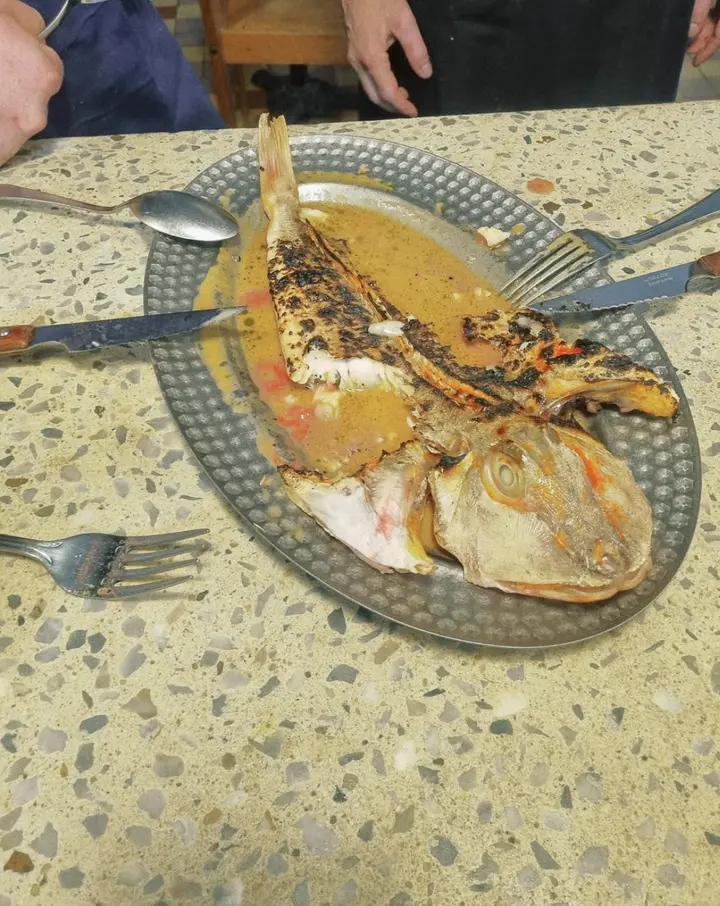Un poisson grillé à partager, posé sur le comptoir avec les couverts
